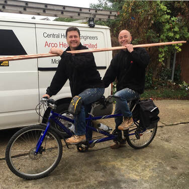 Photo of Martin and Craig on a tandem bike carrying pipes. Arco enjoy what they do and have a fun and friendly disposition
