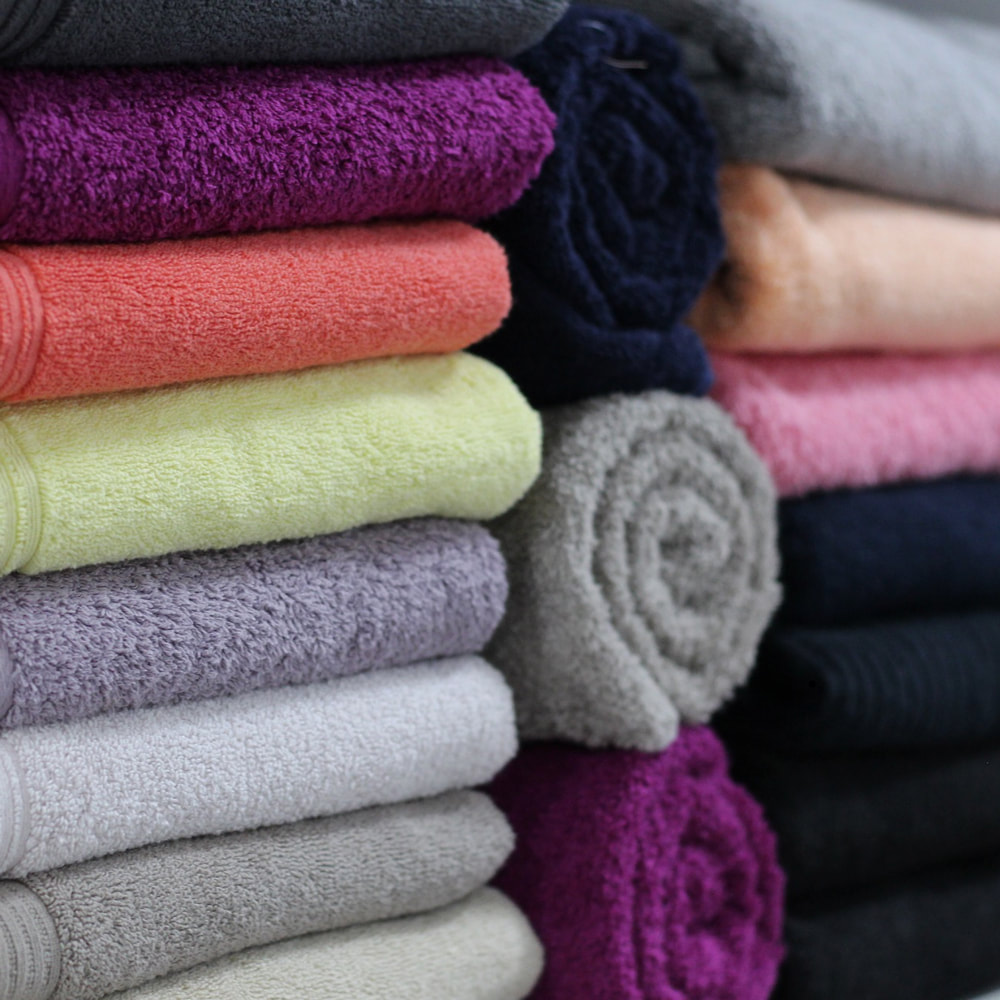 Arco fit bathrooms in Upminster. A tower of different coloured towels that are folded up.
